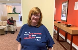 Woman wearing a shirt that reads "feel the power of the disability vote" shirt