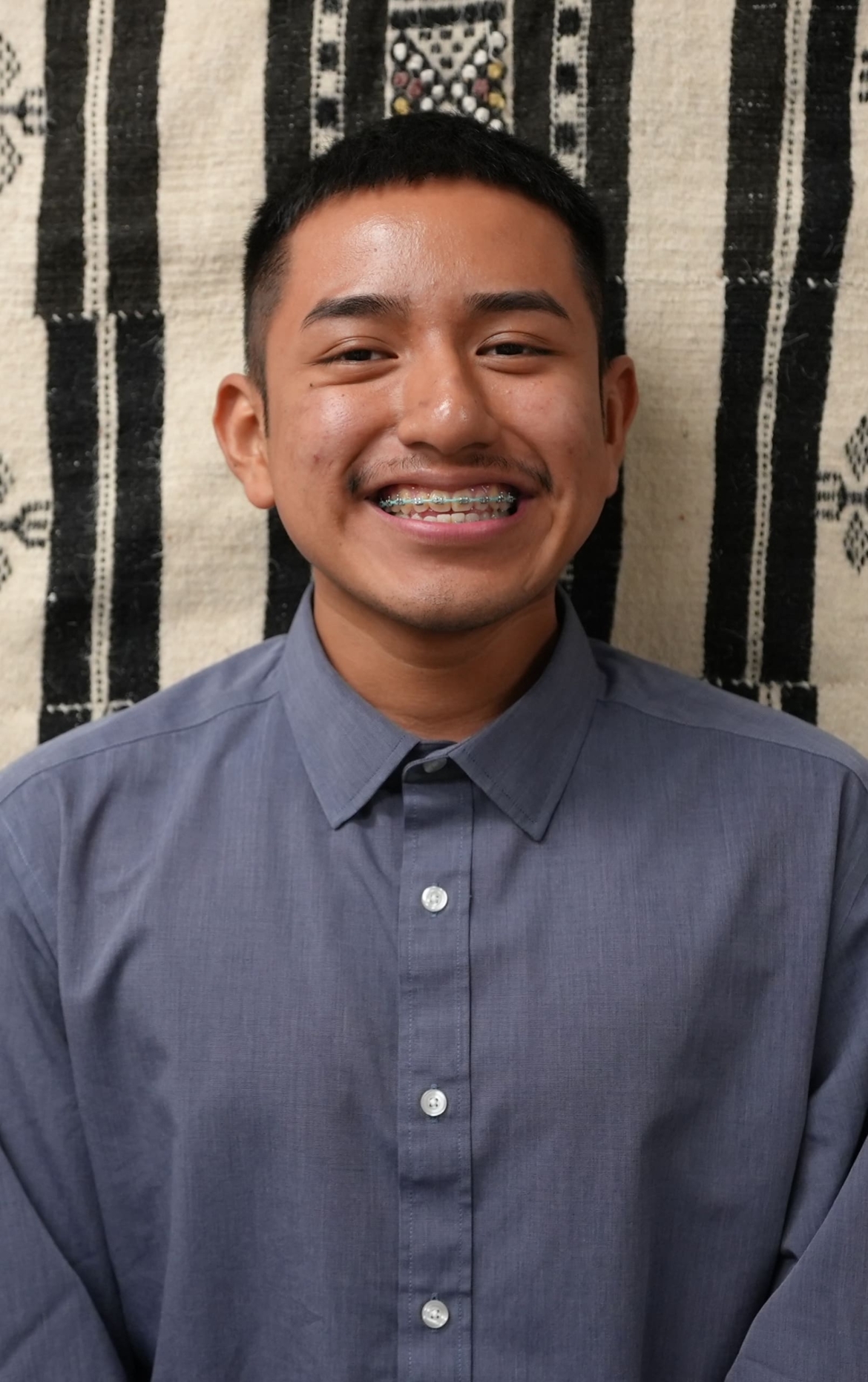 Alex Alejo, a 20-year-old Latino undergraduate student is shown smiling in the photo.